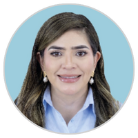 Retrato de una mujer de pelo largo y castaño, con camisa de cuello azul claro, pendientes de perlas y sonriendo, sobre un fondo circular azul claro.