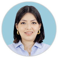Una mujer de pelo oscuro liso, con pendientes de aro dorados y camisa de cuello azul claro, sonríe delante de un fondo circular azul claro.